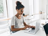 romantic-african-woman-with-trendy-hairstyle-sitting-her-workplace-analysing-data-indoor-portrait-black-female-student-working-with-laptop-before-exam